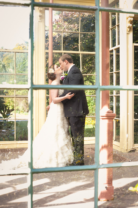 Bride and groom portraits inside the vintage greenhouse at Rockwood Museum Carriage House in Delaware.