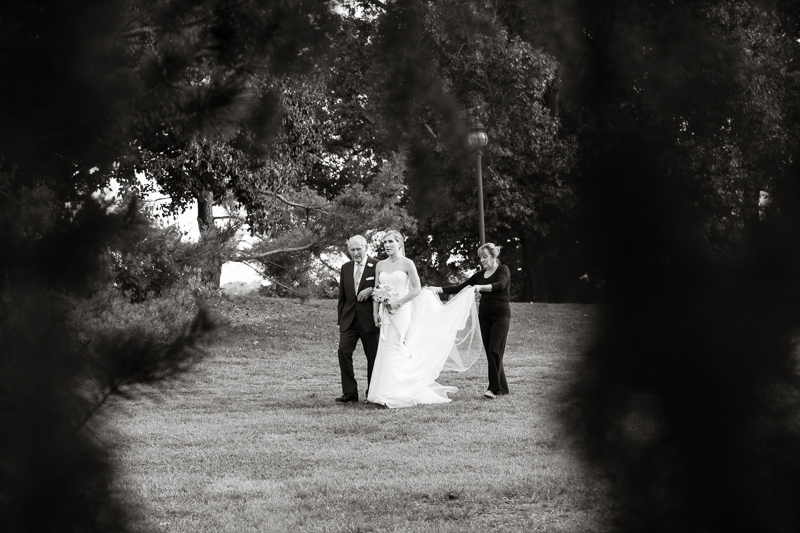 Bride walks down the aisle at her outdoor, fall wedding ceremony at Morris Arboretum in Philadelphia.