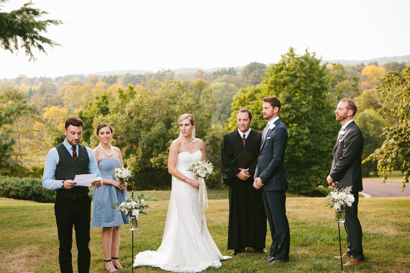 Guests speak during this couple's outdoor fall wedding ceremony at Morris Arboretum in Philadelphia.