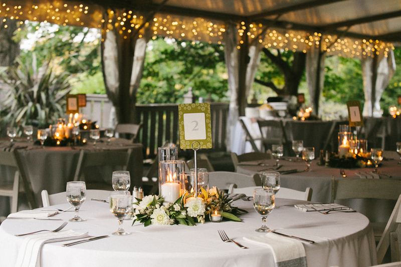A unique outdoor wedding reception among romantic string lights and candles at Morris Arboretum. 