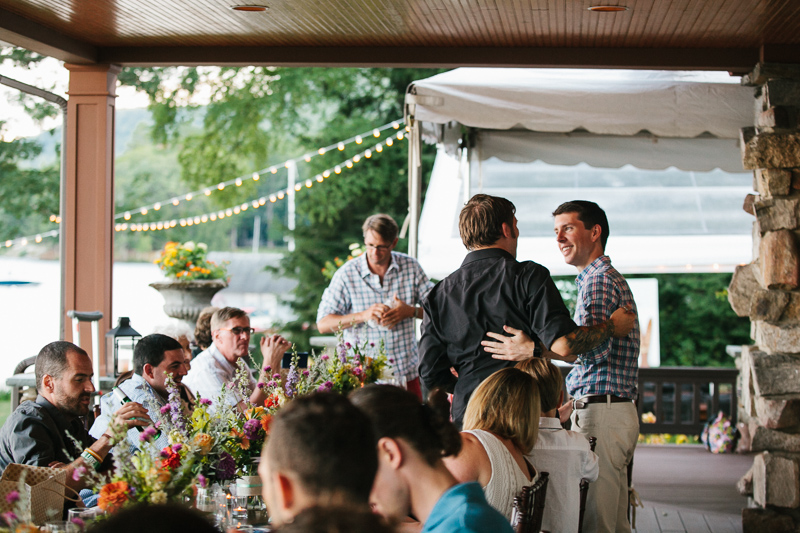 Friends and guests celebrate this lakeside rustic wedding at the rehearsal dinner at Lake George in New York.