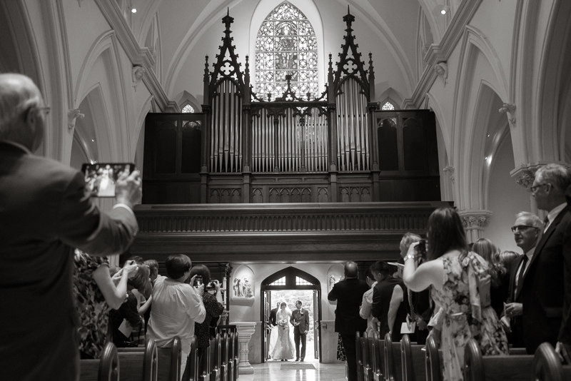 Bride walks down the aisle with father at her wedding ceremony in Villanova Chapel.
