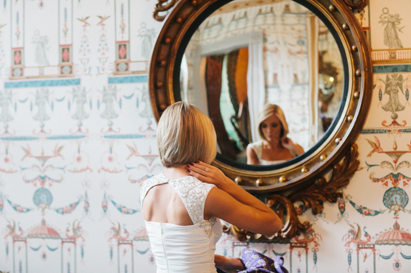 Bride standing in front of an ornate mirror at the Overbrook Golf Club in Villanova, Pennsylvania.