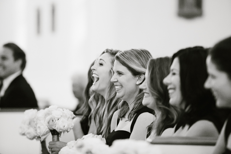 Bridesmaids laugh candidly as the bride and groom get married during this wedding ceremony near Philadelphia.