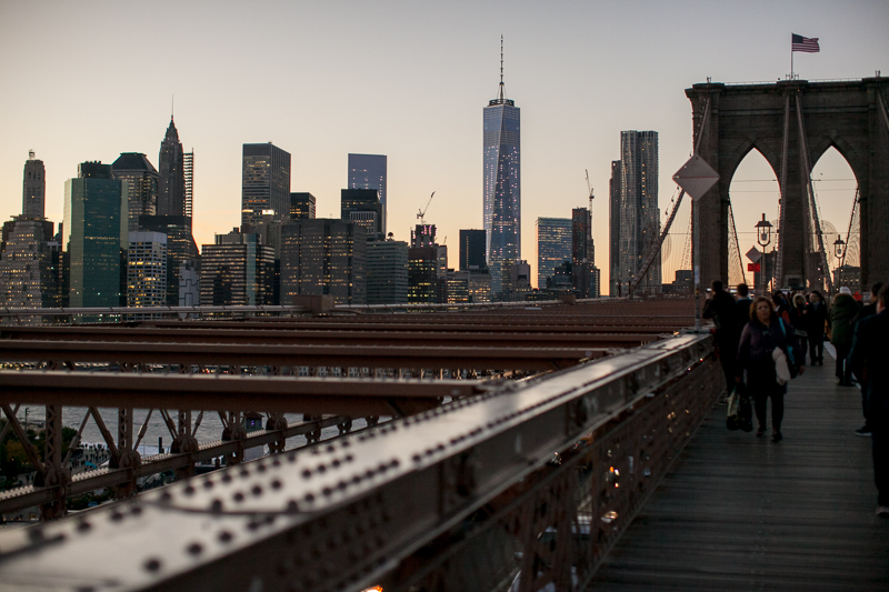 Perspective from the Brooklyn bridge of the NYC skyline at dusk during this urban engagement session in Dumbo.