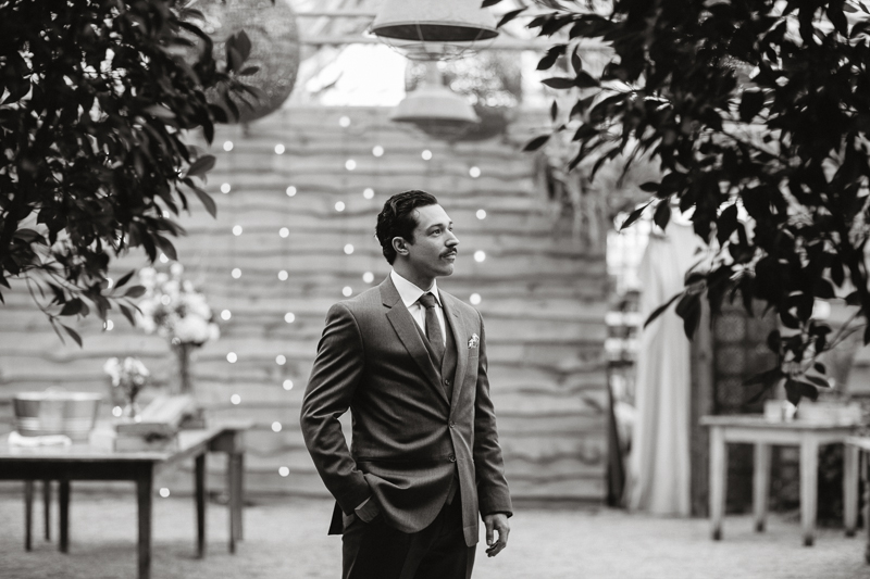 A black and white portrait of the groom before the outdoor garden wedding ceremony at Terrain.