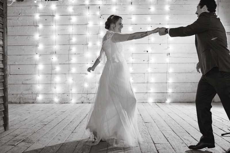 Bride and groom dance in front of a string-light covered wall at Terrain, which is near Philadelphia.
