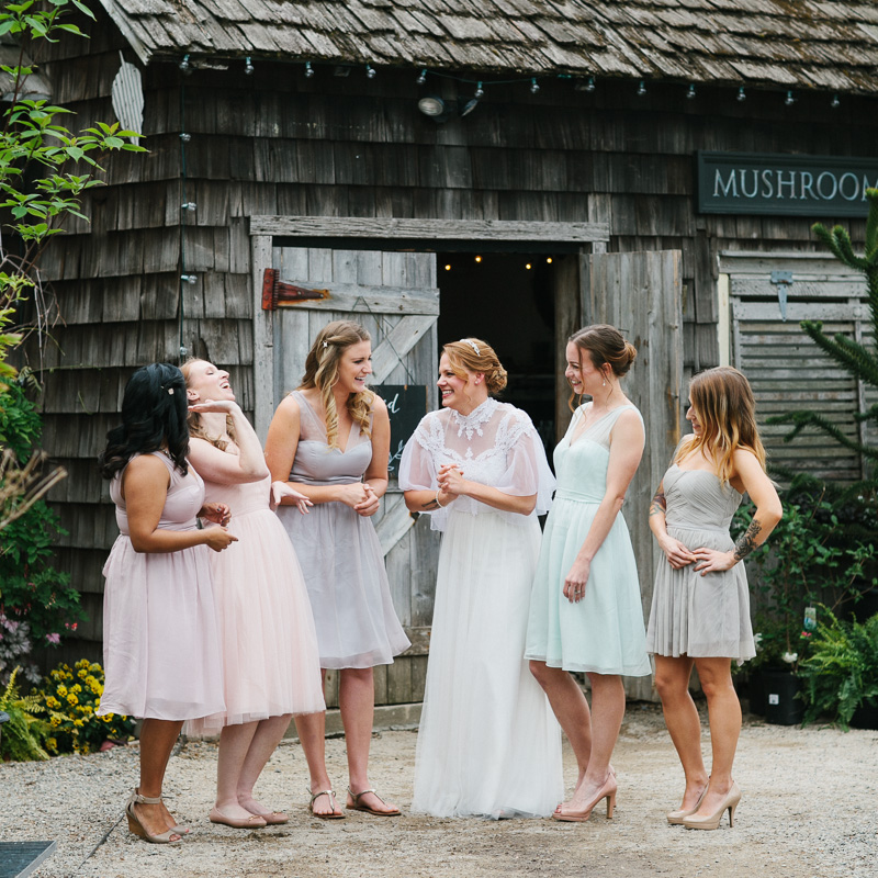A bride laughing with her bridesmaids in front of the Mushroom House at Terrain.