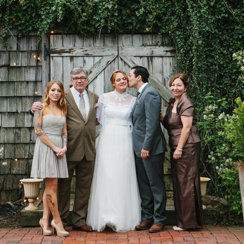 Unique family portraits in front of an aging vintage door at a garden-themed wedding.