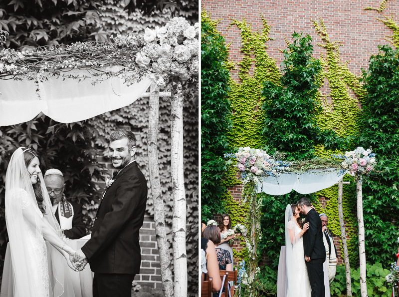 Bride and groom stand under a floral chuppah