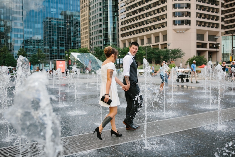 Bride and groom walk through the water at Dilworth Park in Philadelphia.