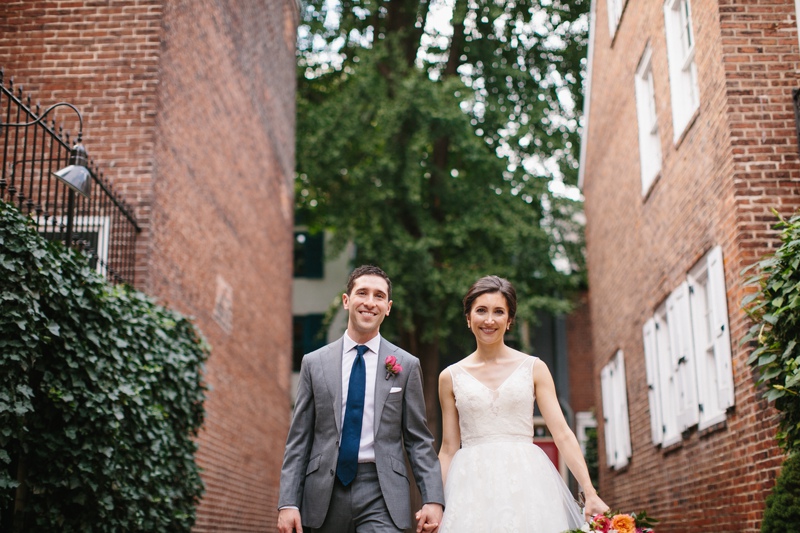 Bride and groom walk down classic cobblestone streets in Philadelphia before their wedding ceremony.