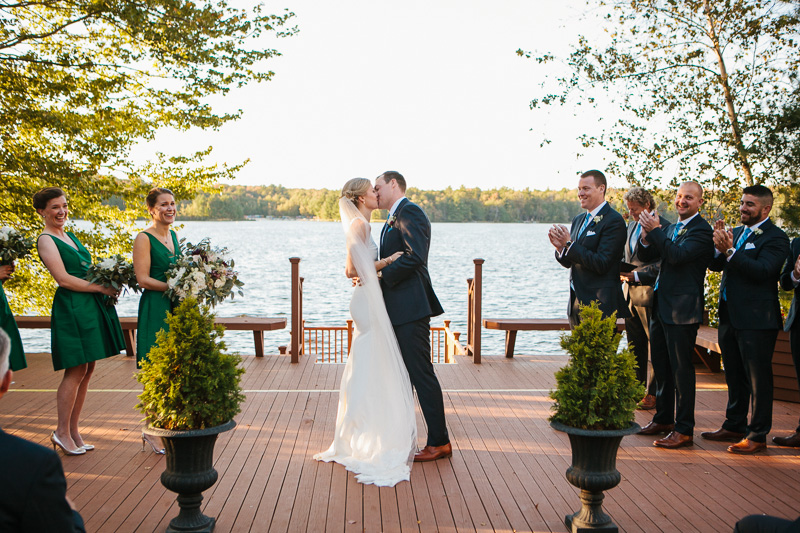Bride and groom's first kiss during their modern, outdoor wedding.