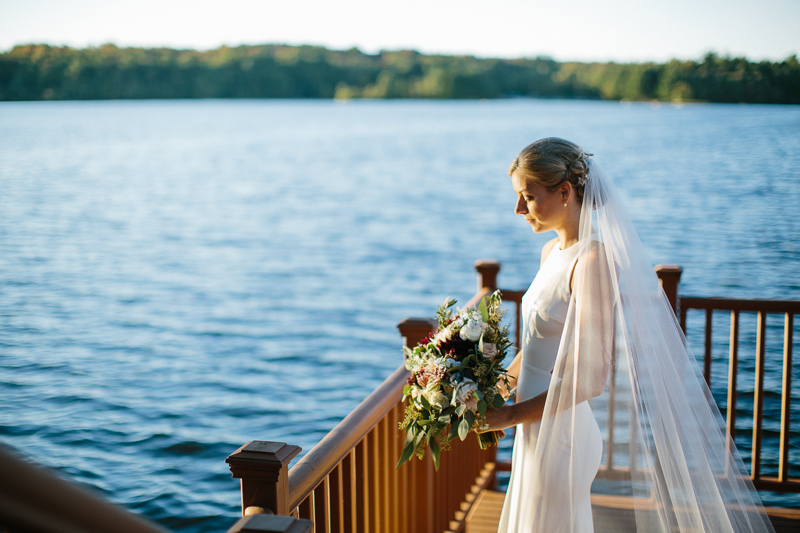 Modern lake portraits of a bride before her outdoor Poconos wedding.