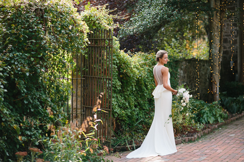 elegant bride in ivy covered stone courtyard garden at Hollyhedge estate