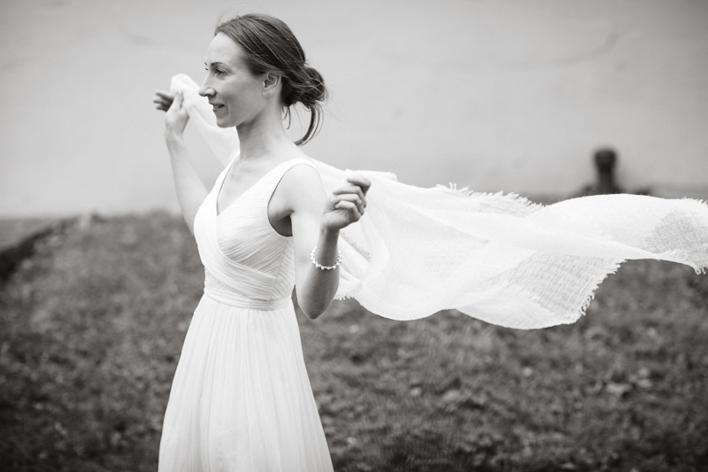 A bride enjoys the details of her dress at her intimate Quaker wedding in Pennsylvania.