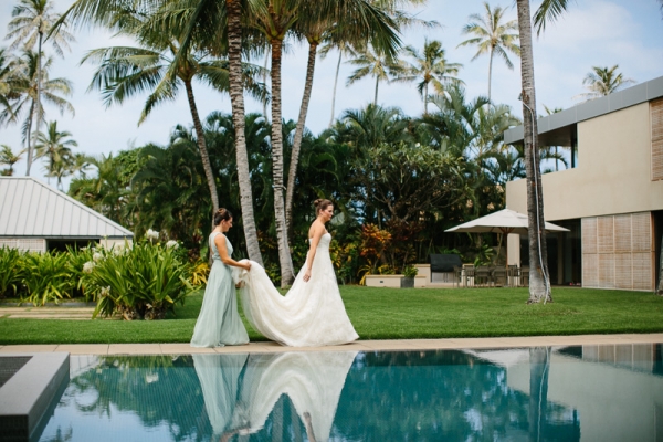 Bride walks along the pool outside before her wedding in Waikiki, Hawaii.