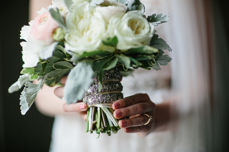Details of the bride's bouquet and dress before her modern wedding ceremony.