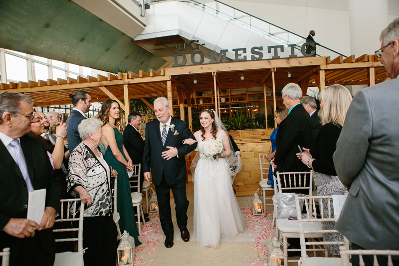 Bride walks down the aisle with her father during her modern Cira Centre wedding.