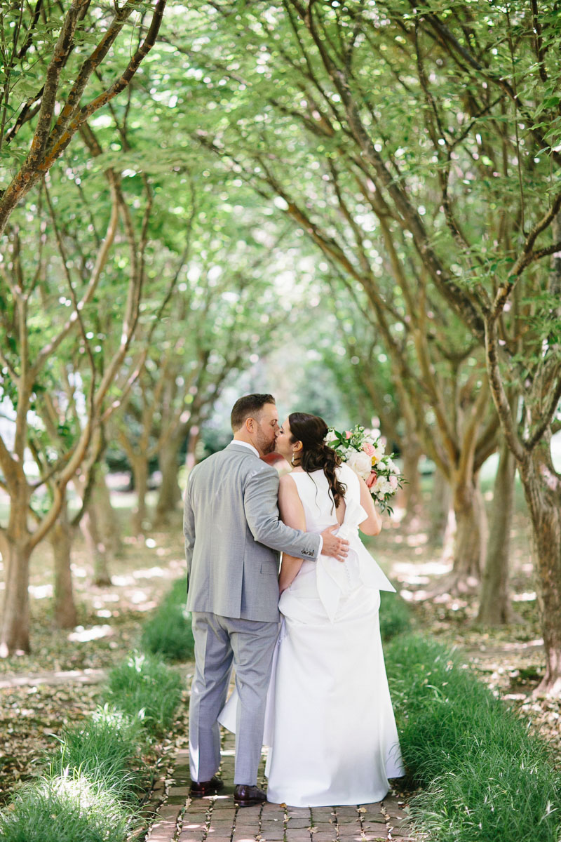 Bride and groom walk through the trees at Appleford Estate.
