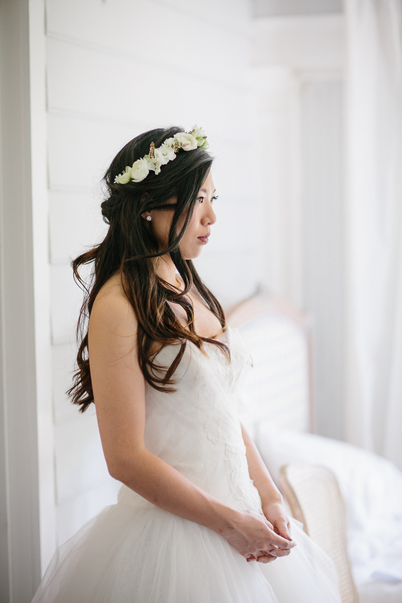Bride gets ready with her floral crown before her summer wedding.
