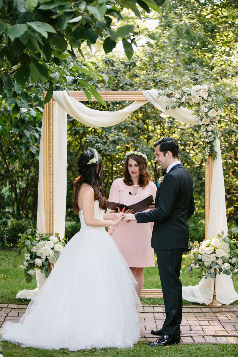 Bride and groom get married under a gorgeous gold frame at Fernbrook Farms.
