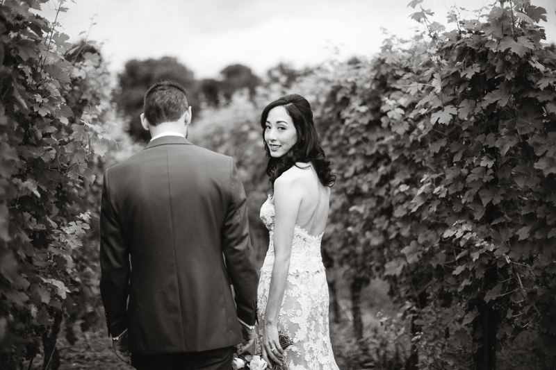 Black and white portraits of the bride and groom among the vineyard at Grace Winery.