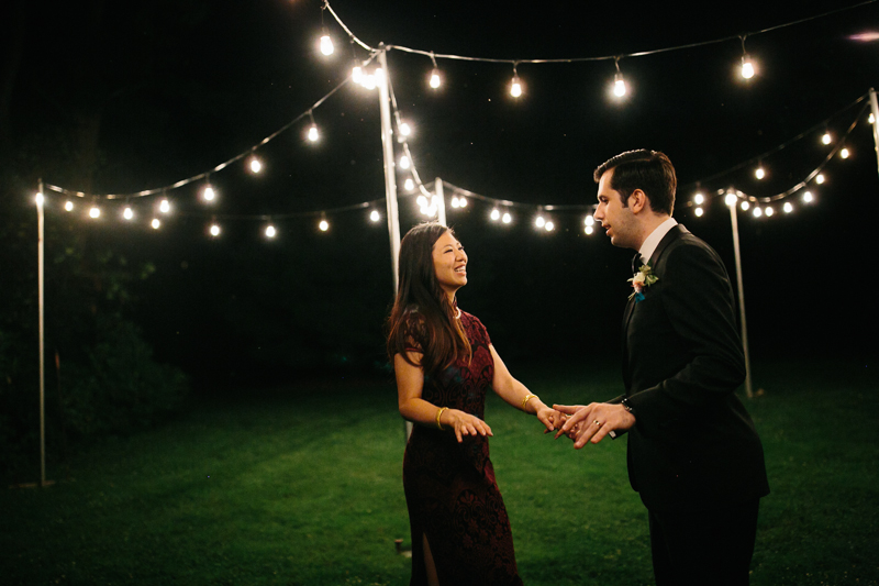 Bride and groom dance outside under the rustic lights at Fernbrook Farms in New Jersey.