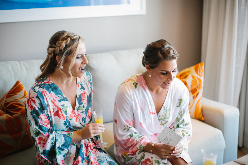 Bride opens gifts and letters with her bridesmaids before her modern wedding ceremony.