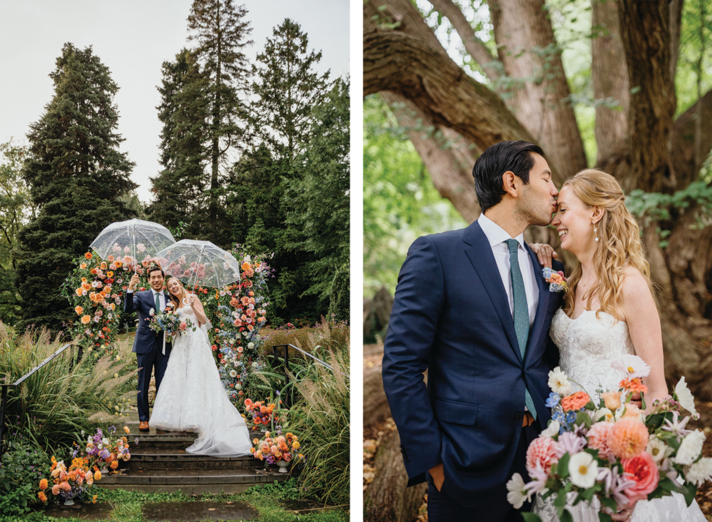 Groom wearing a navy blue suit kissing bride's forehead in front of trees in the forest.