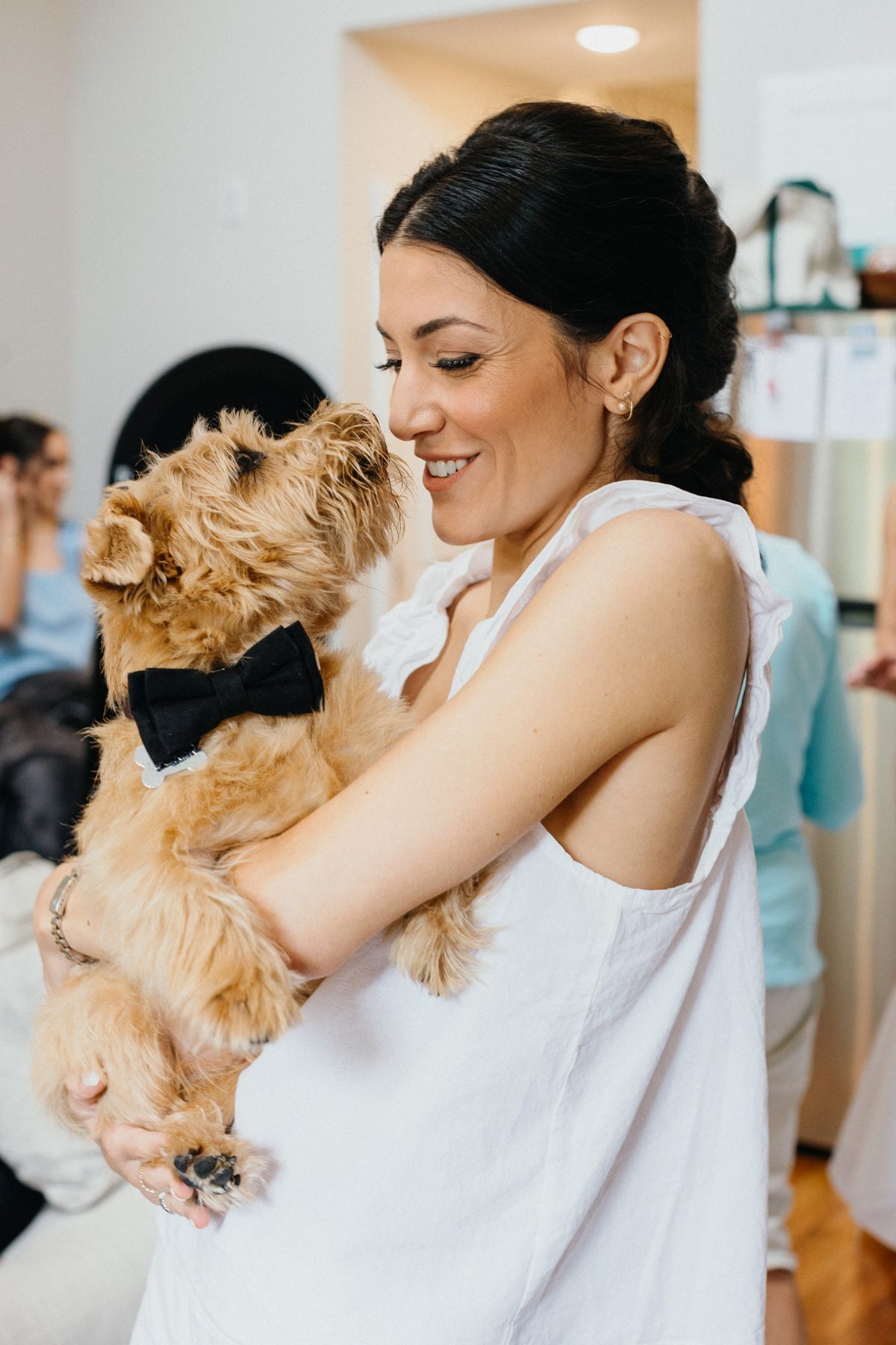 Bride making a kissy face at her dog on the morning of her wedding.