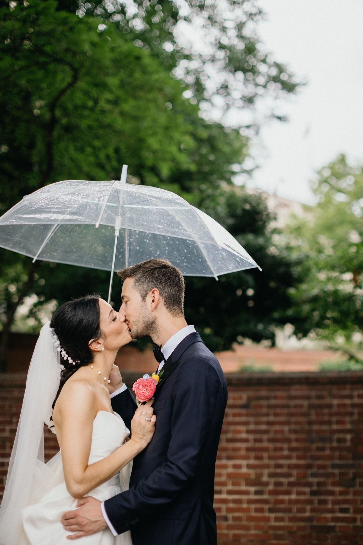 Bride and groom kissing under an umbrella in a historic alley in Old City, Philadelphia.