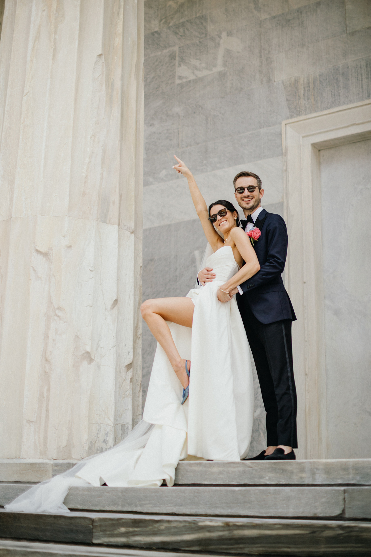 Fun portrait of bride and groom outside of the Merchant Exchange Building in Philadelphia, PA.