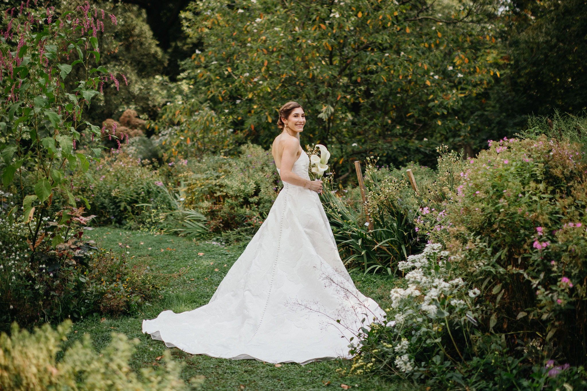 Bridal portrait in the garden surrounded by full blooms.