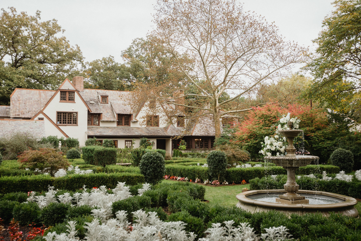 Garden and elegant fountain in front of Hotel Du Village, a cottage like estate wedding venue.