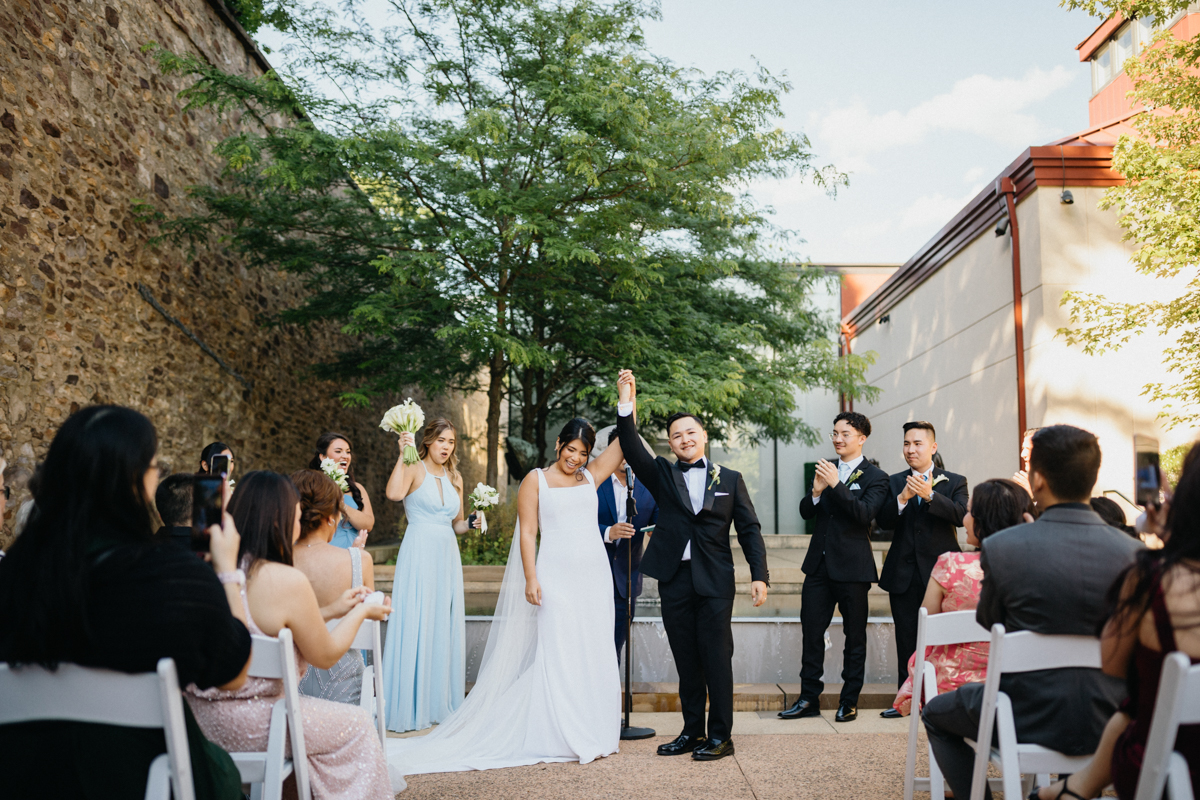 Bride and groom cheering after they exchanged vows during their outdoor ceremony at James A. Michener Museum in Bucks County.