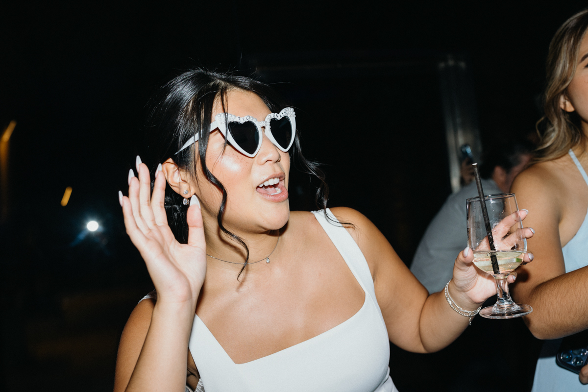 Bride placing hand to ear as if she's listening for music.