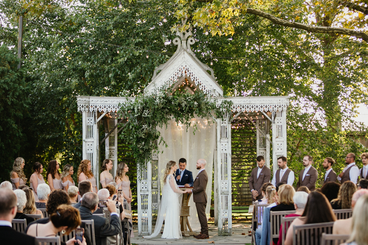 White unique wedding ceremony backdrop resembling a trestle.