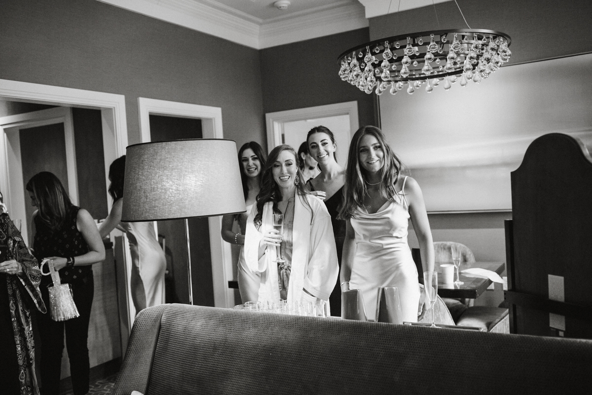 Black and white photo of brides maids reacting to seeing the brides dress.