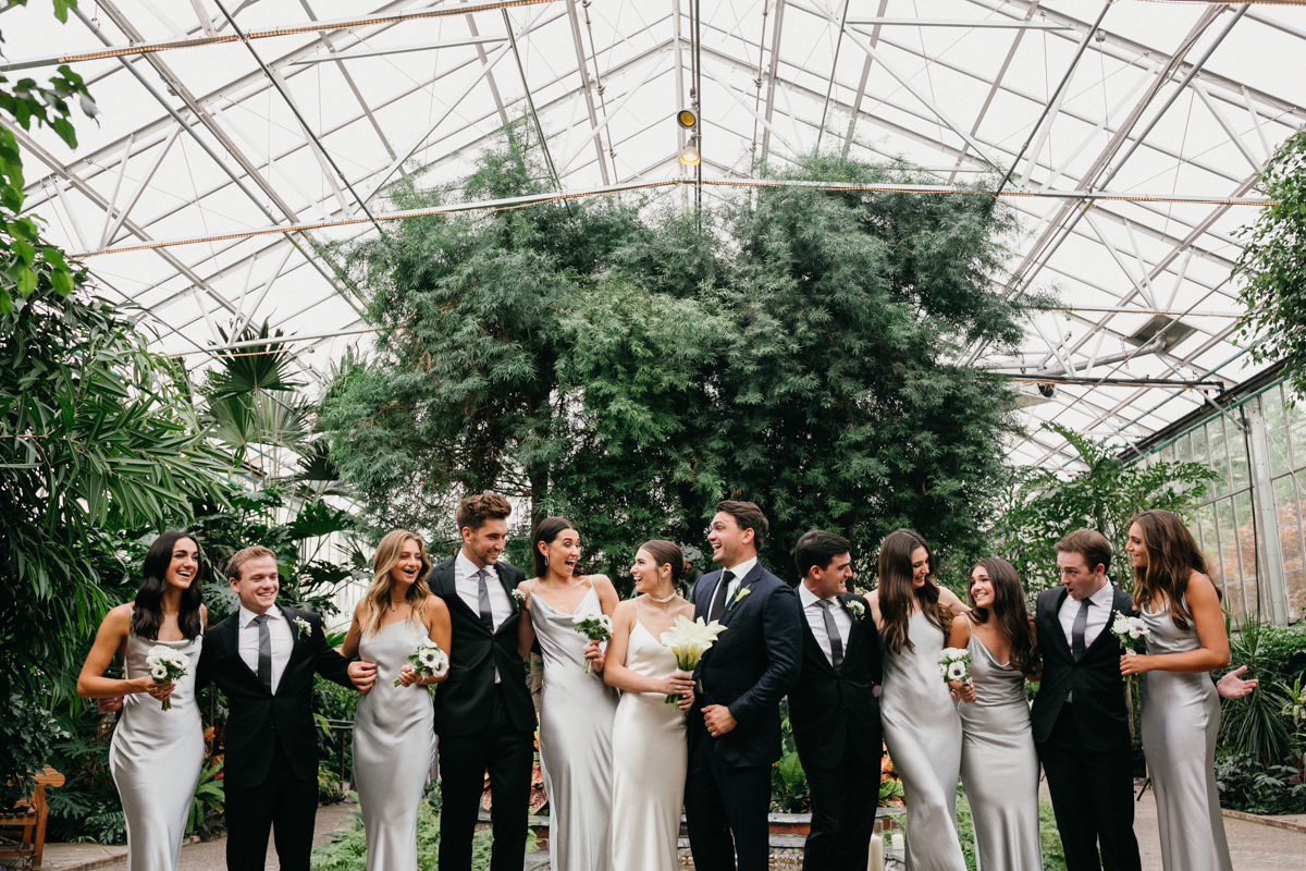 Bridal party portrait in large greenhouse.