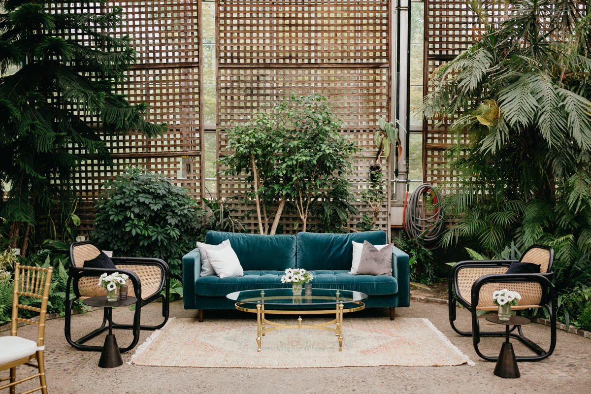 Retro velvet furniture in a greenhouse space.