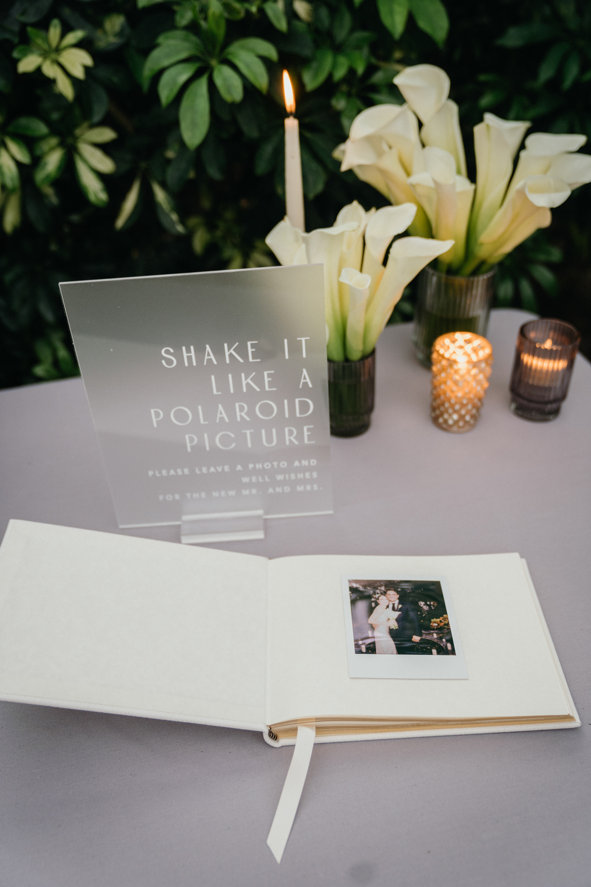 Polaroid wedding guestbook with a sign that says "shake it like a polaroid picture."