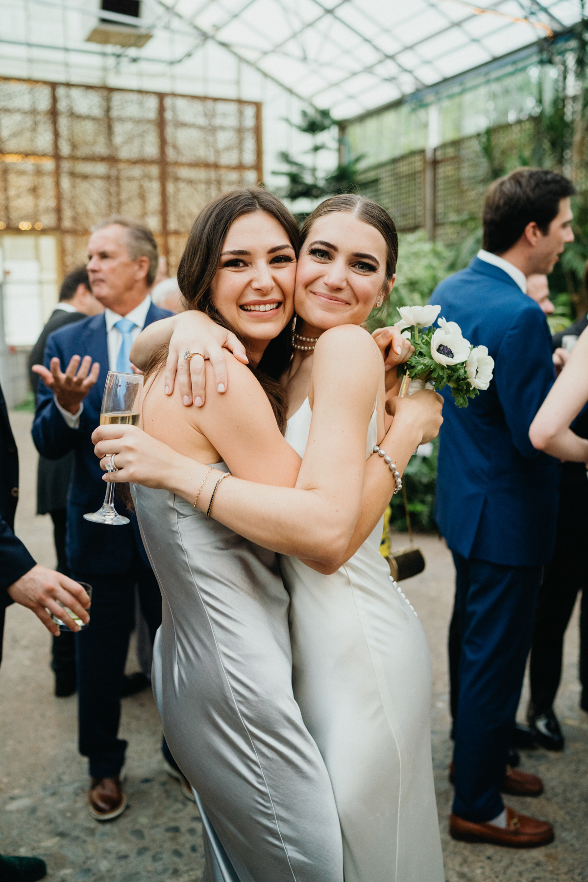 Bride hugging friend at her wedding cocktail hour.