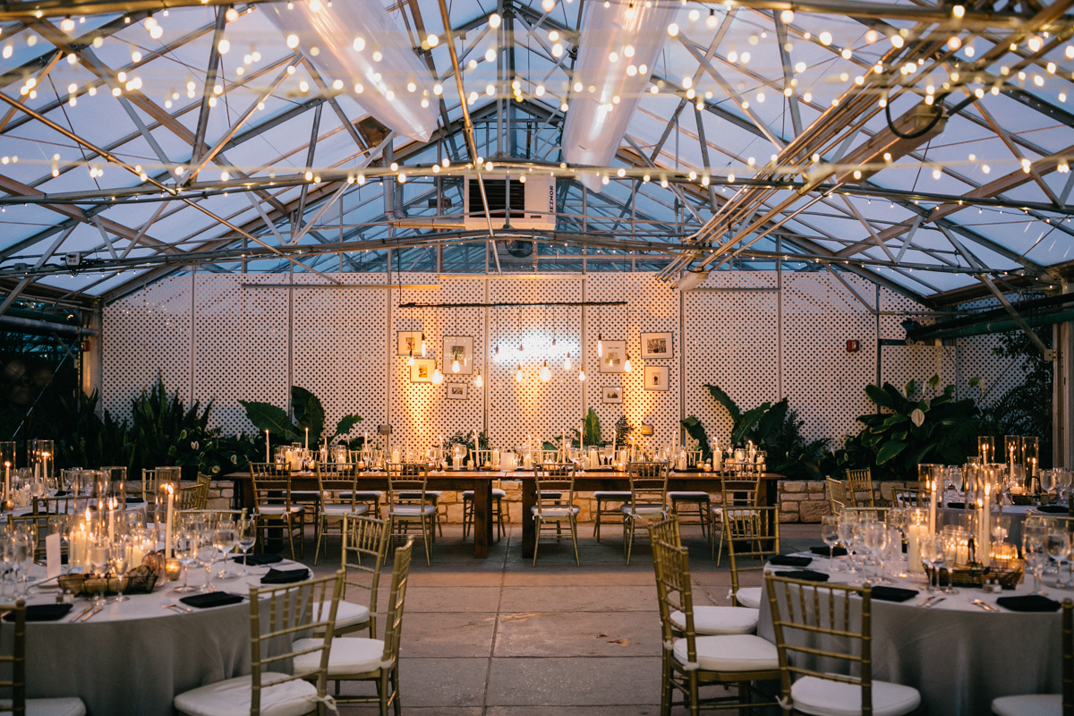 Greenhouse wedding reception with warm lighting.