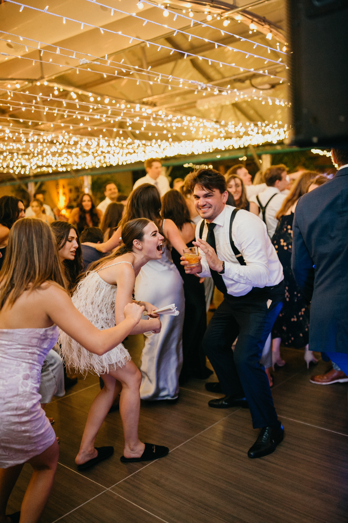 Couple dancing on the dance floor as the bride twists lower to the floor and groom crouches down.