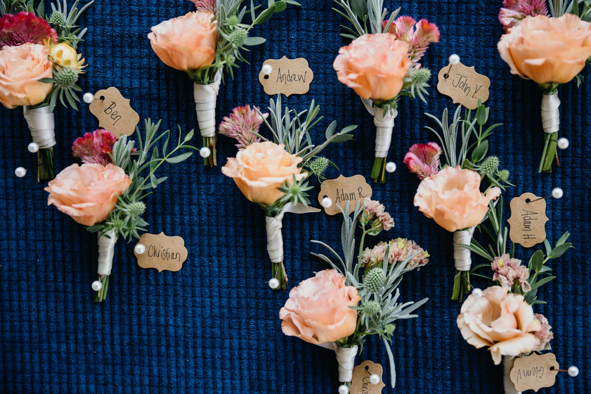 Light peach boutonnieres pinned to a navy blue cloth 