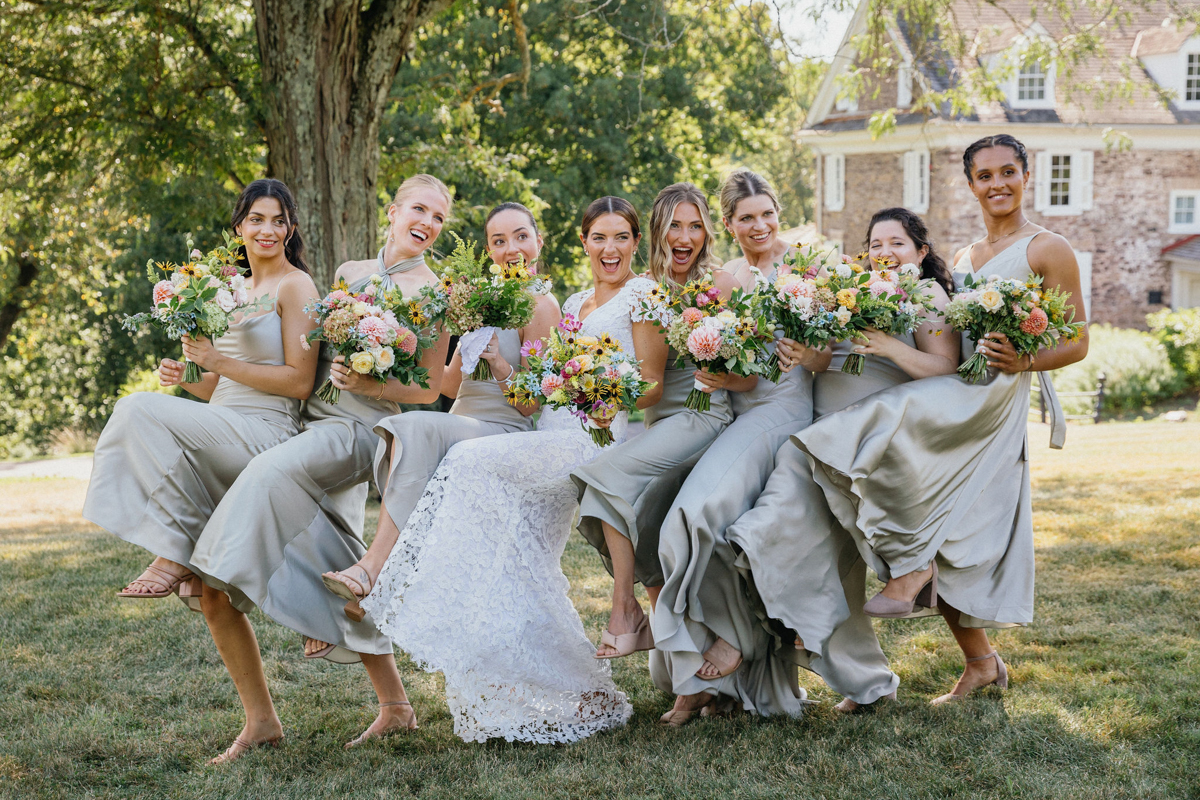 Toni and her bridesmaids in a kick line laughing and smiling. 