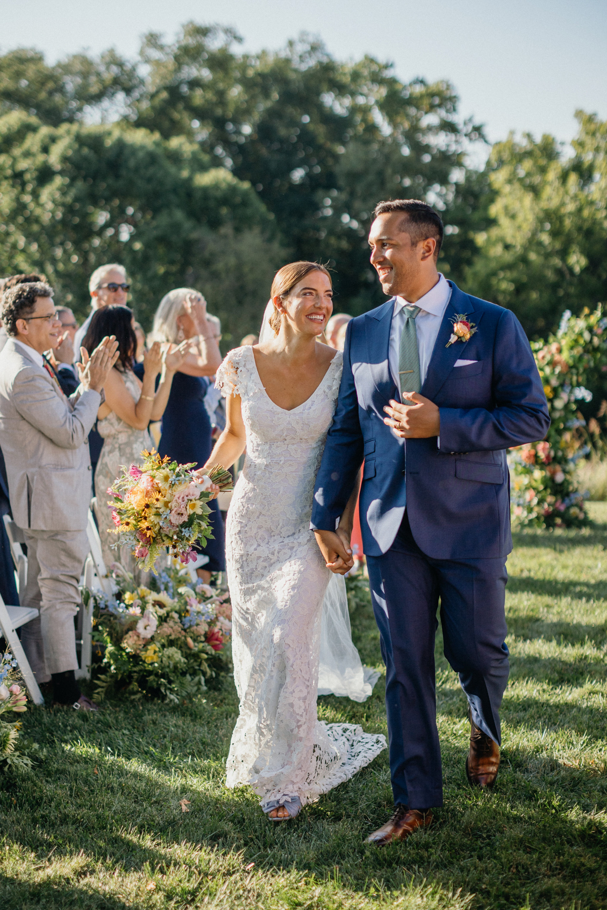 Couple walking down the aisle smiling and laughing at each other. 