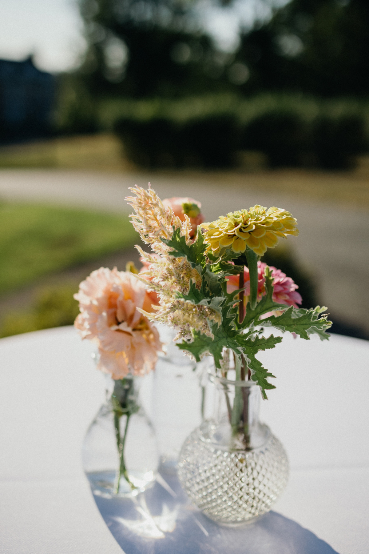 Simple bud vases with pink and yellow flowers.