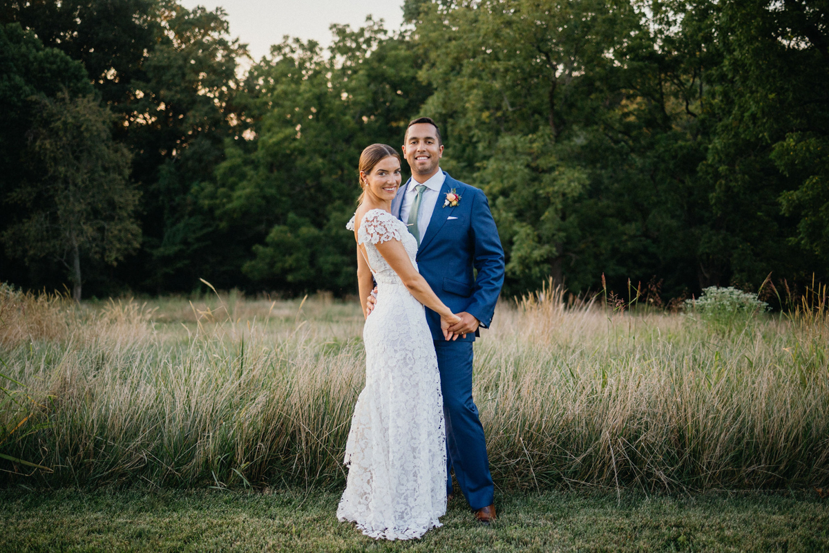 Informal portrait of bride and groom in a field.